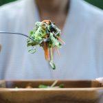 a person eating a salad with a fork